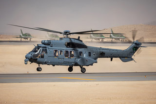Prince Khalid bin Salman bin Abdulaziz arrives at the World Defense Show 2024 while the Saudi Hawks hold before take off in the background.